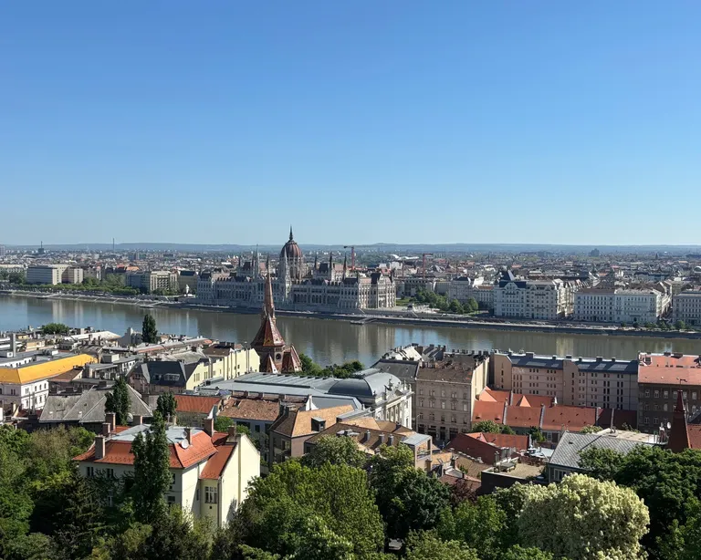 Blick auf Budapest mit Fluss, vielen Häusern und einer Kirche im Zentrum unter klarem, blauem Himmel. auf der Konfreise