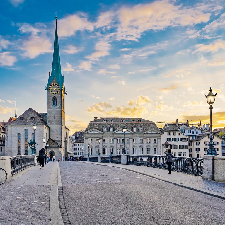Blick auf die Münsterbrücke in Zürich mit historischen Gebäuden, links das Fraumünster mit Turm, rechts der St. Peter-Turm.