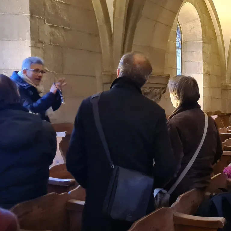 Der ehemalige Sigrist erklärt einer Gruppe von Gästen ein Steinmetzzeichen auf der Empore im Grossmünster.