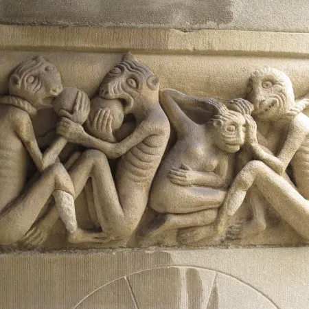 Steinerne Reliefskulptur mit drei dämonischen Kreaturen und einer Person in gebeugter Haltung, Detail aus dem Kreuzgang Grossmünster.