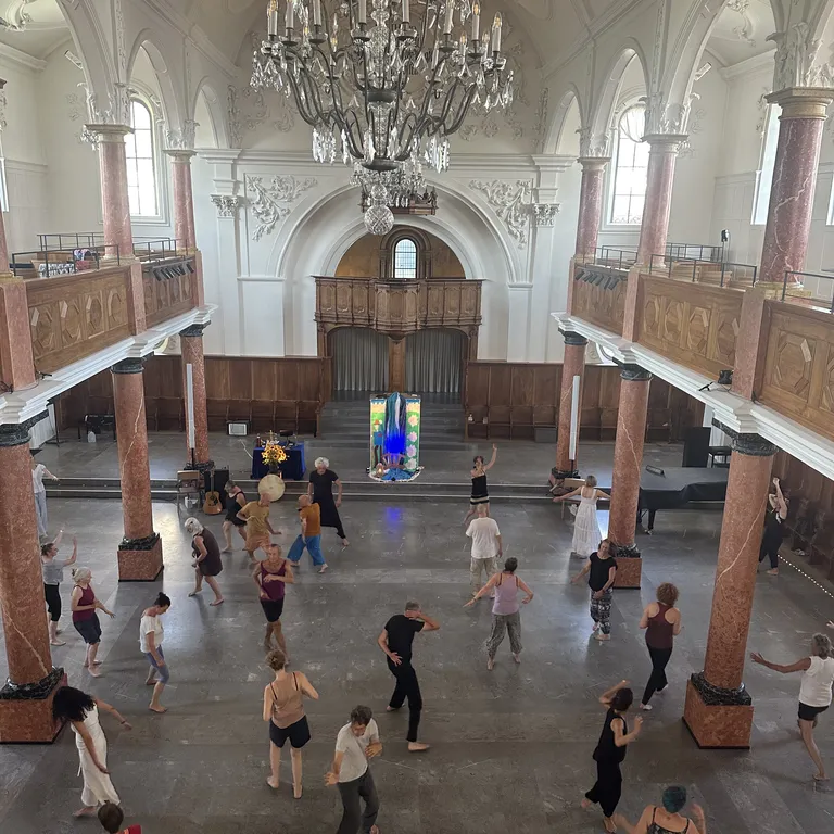 Menschen tanzen in der Stadtkirche St. Peter in Zürich