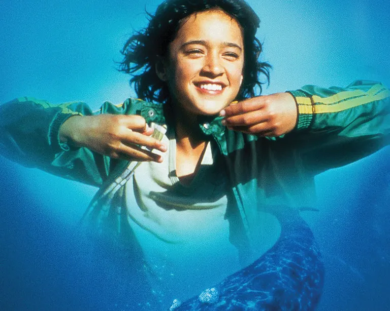 Mädchen im Meer unten ein grosser Wal
