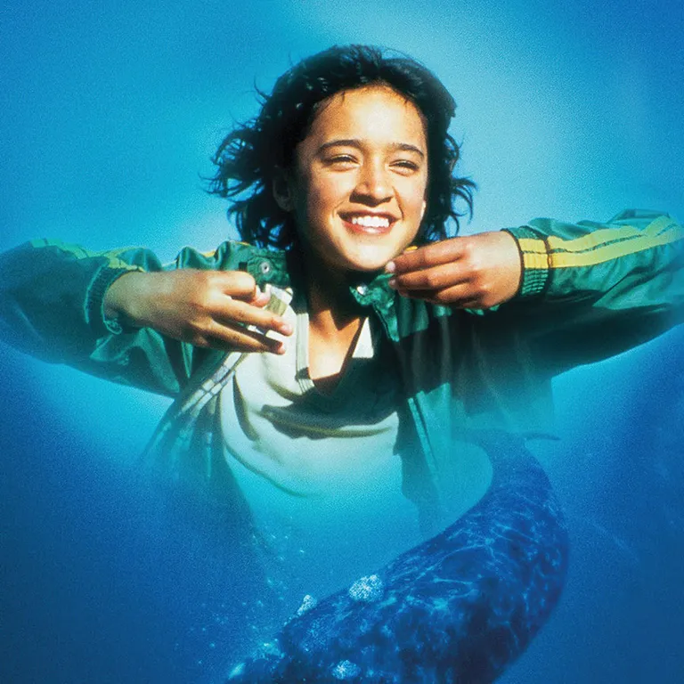 Mädchen im Meer unten ein grosser Wal