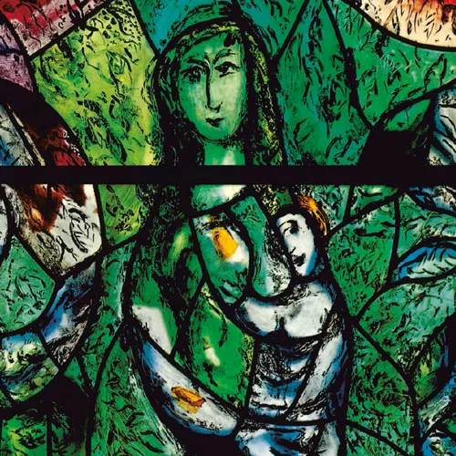 Buntglasfenster mit grüner Frau, die ein Kind im Arm hält, umgeben von abstrakten Mustern und Blättern.