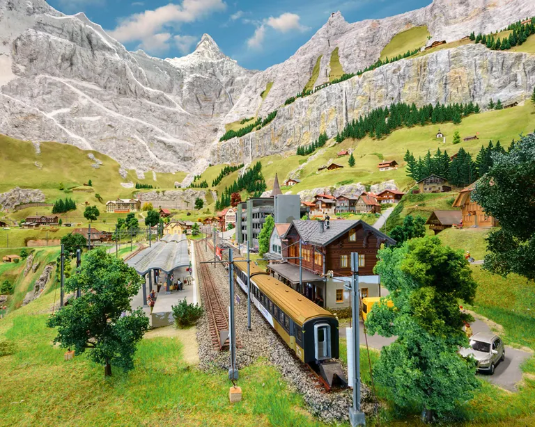 Zugstrecke mit Bahnhof und Bergen in Miniaturwelt