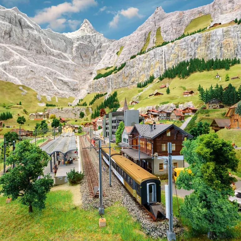 Zugstrecke mit Bahnhof und Bergen in Miniaturwelt