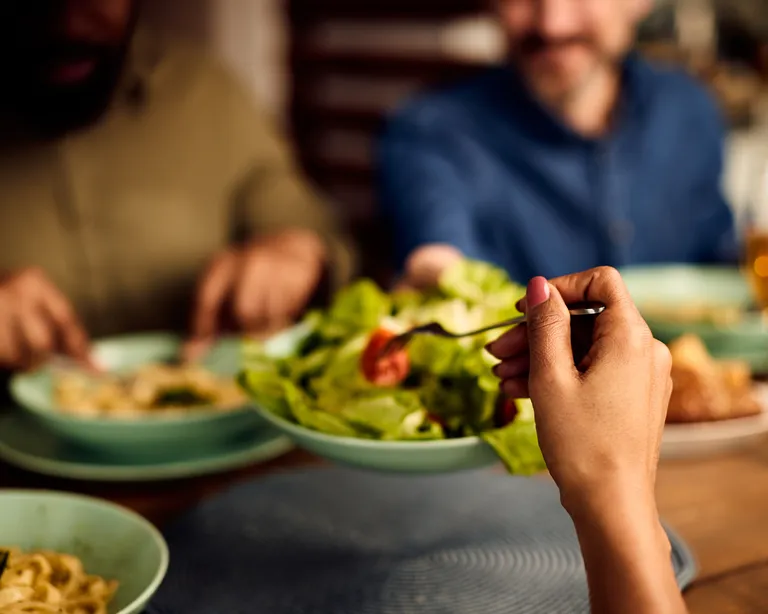 Mehrere Personen sitzen an einem Tisch und essen gemeinsam beim Anlass «Mittagessen für Alle» im Sonnegg